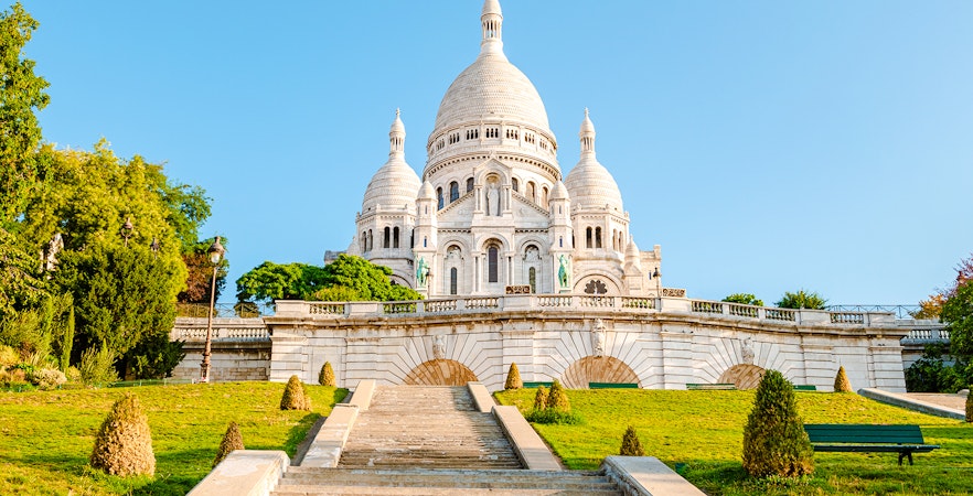 Sacré-Cœur Basilica exterior with steps and greenery in Paris, France.