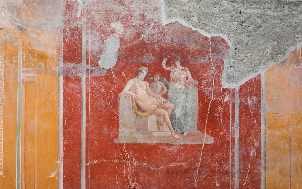 Ancient fresco depicting mythological figures in Pompeii ruins.