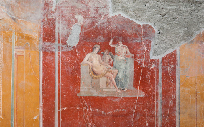 Ancient fresco depicting mythological figures in Pompeii ruins.