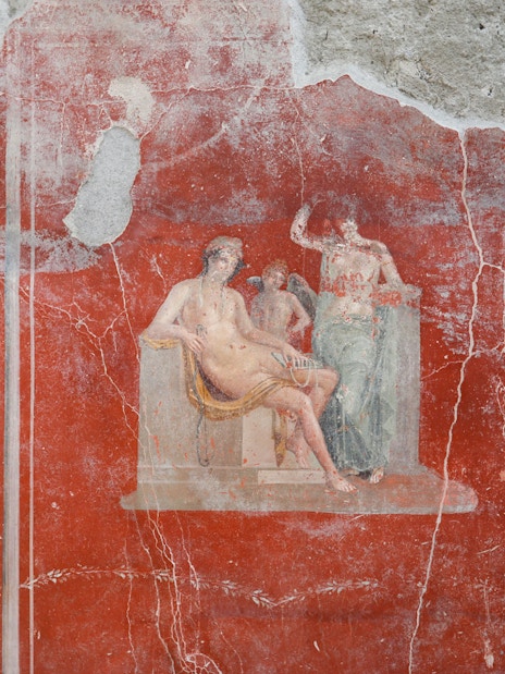 Ancient fresco depicting mythological figures in Pompeii ruins.