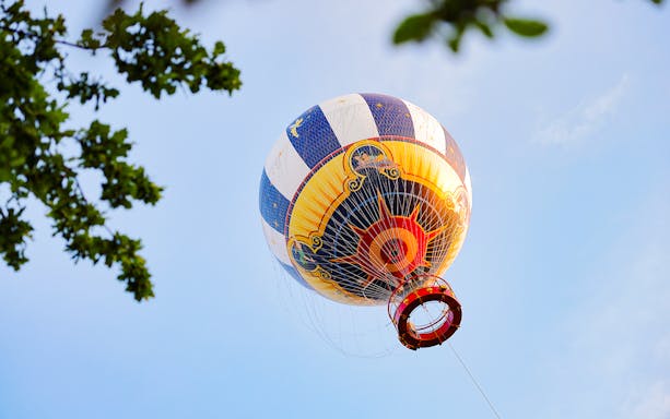 Ballon Panoramagique hot air balloon against blue sky in Paris.