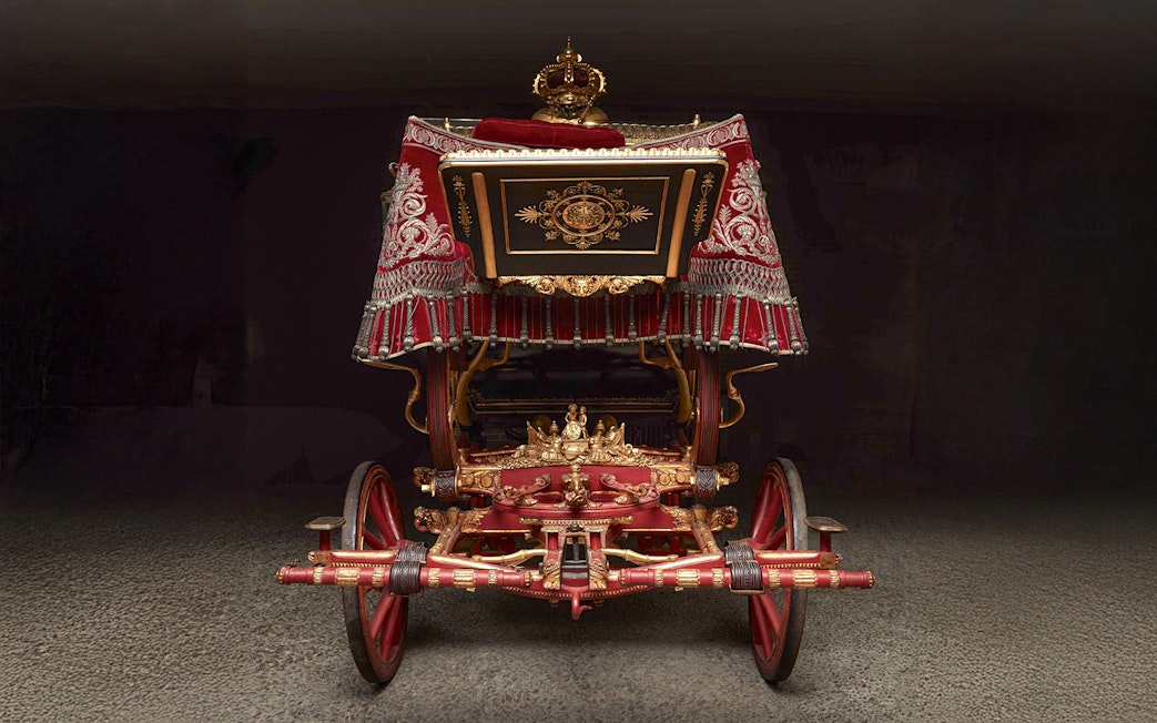 Ornate royal carriage on display at the Royal Collections Gallery.