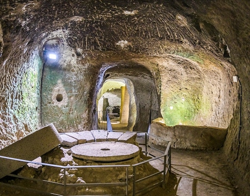 Orvieto Underground cave with ancient millstone and stone walls.