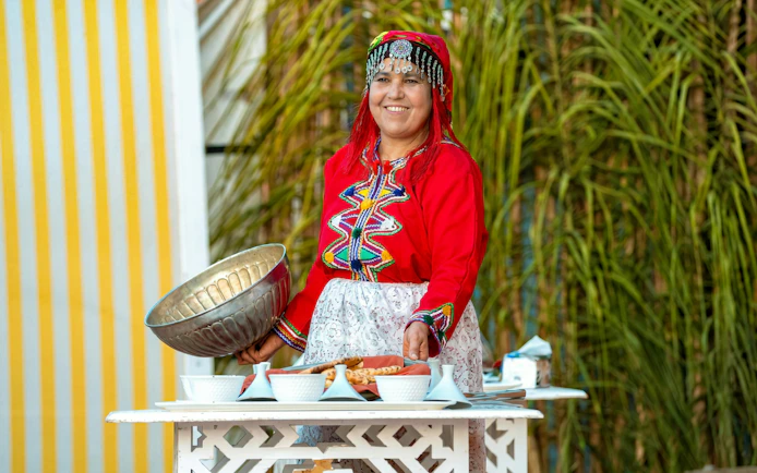 Berber woman in traditional attire preparing dinner at Agadir Fantazia Night Show.