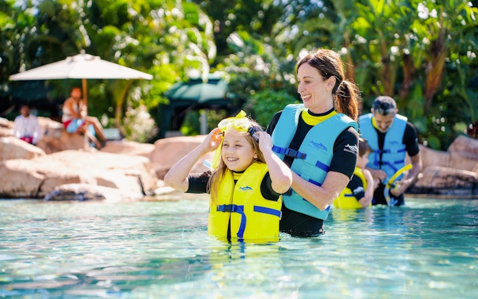 Child and adult in life vests enjoying water activities at Discovery Cove Orlando.