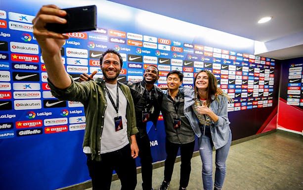 Group taking selfie at FC Barcelona Camp Nou stadium press area.
