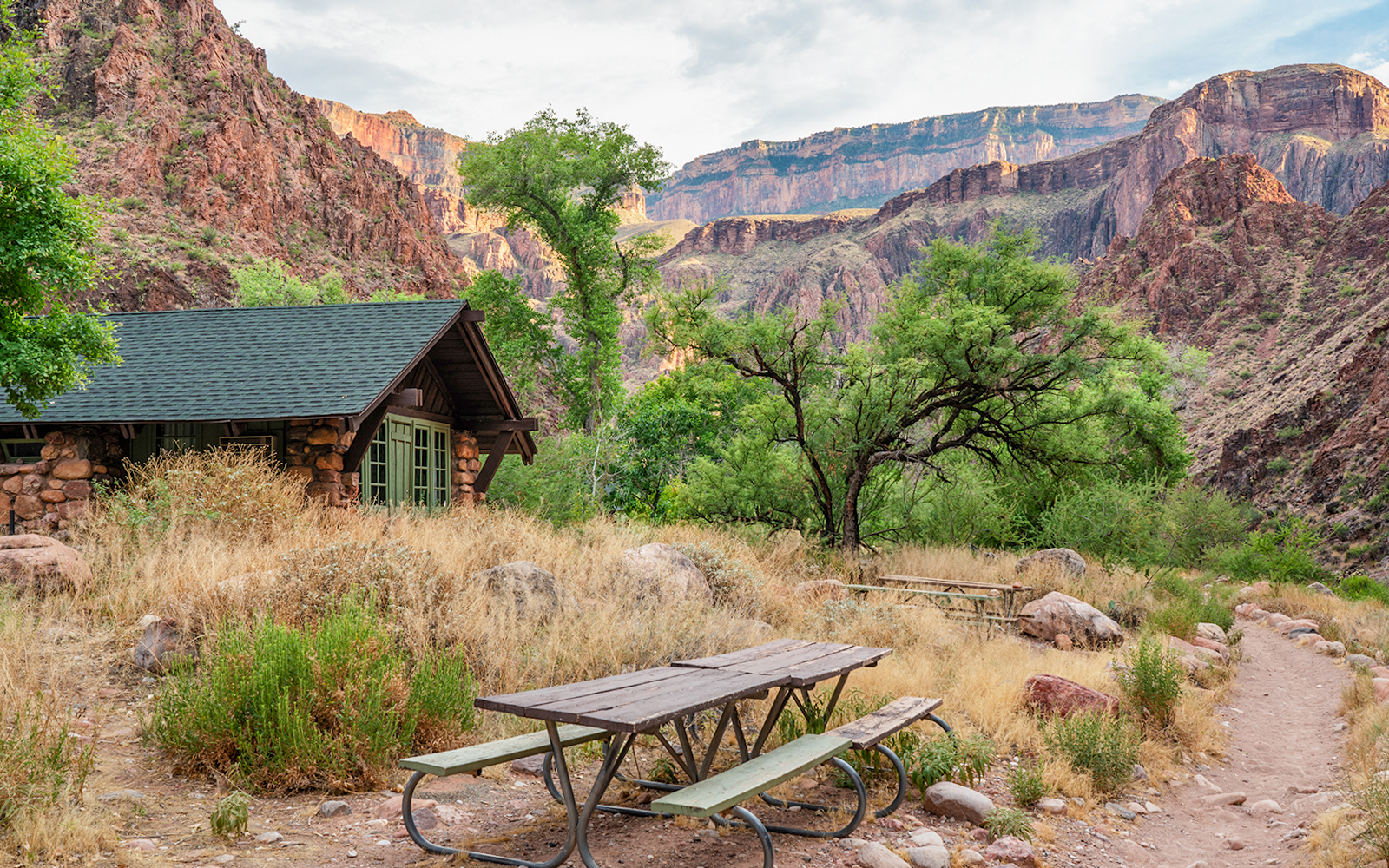 Phantom Ranch cabin and picnic area with Grand Canyon cliffs in the background.