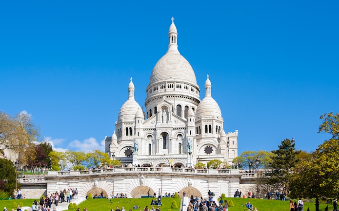 Montmartre Sacré-Cœur Cathedral with visitors on the lawn, Paris.