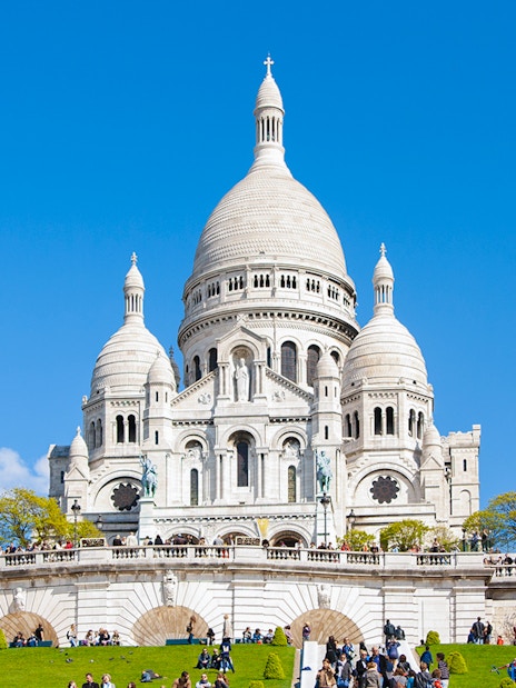 Montmartre Sacré-Cœur Cathedral with visitors on the lawn, Paris.