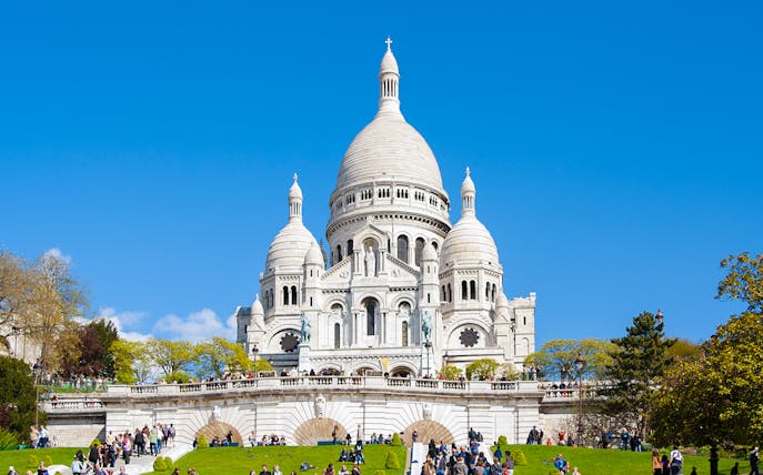 Montmartre Sacré-Cœur Cathedral with visitors on the lawn, Paris.