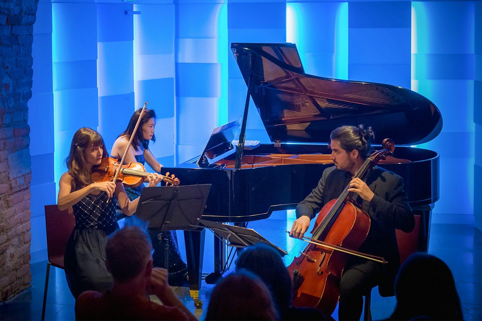 Musicians performing at Mozarthaus concert in Vienna with violin, cello, and piano.
