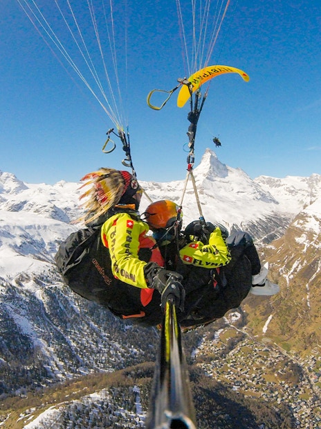 Paragliding over snowy Matterhorn with guide in Switzerland.