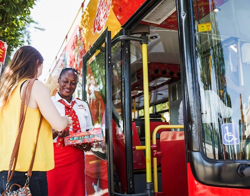 Woman boarding onto a Hop On Hop Off Bus