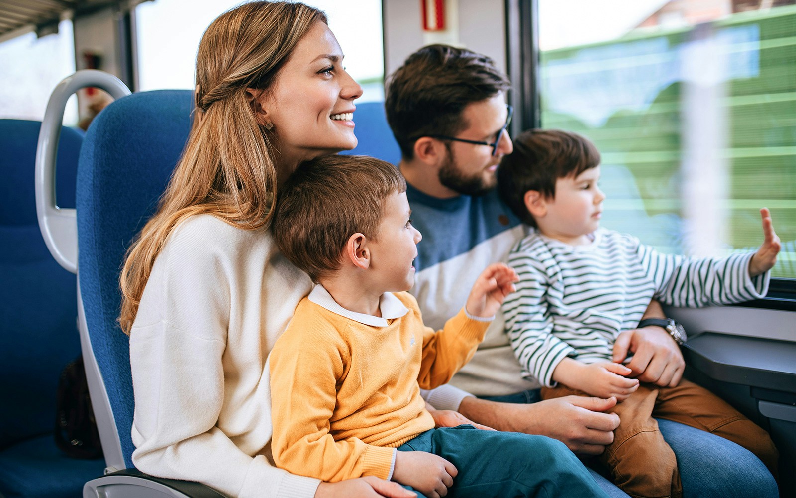 Family enjoying a fast train journey together, looking out the window.