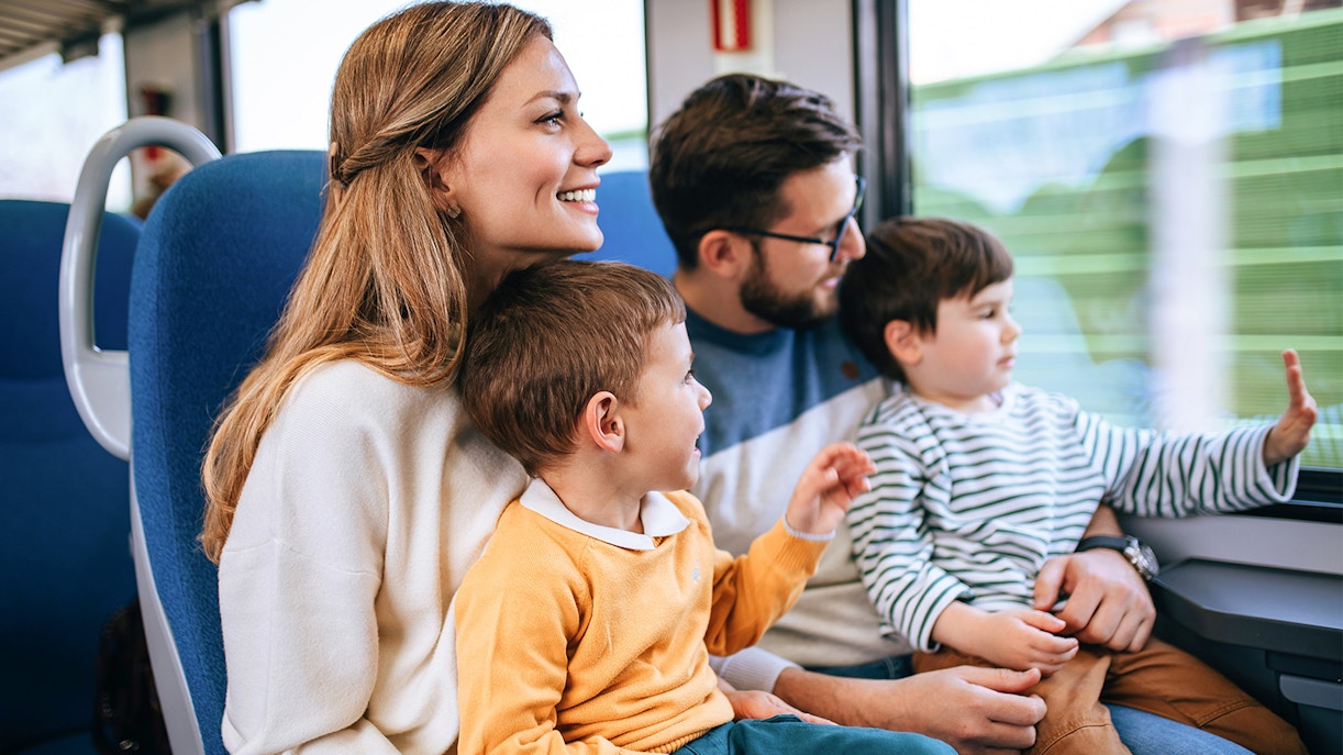 Family enjoying a fast train journey together, looking out the window.