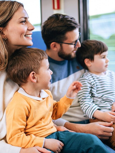 Family enjoying a fast train journey together, looking out the window.