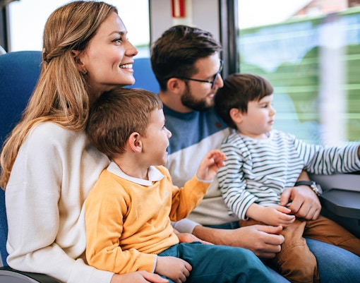 Family enjoying a fast train journey together, looking out the window.