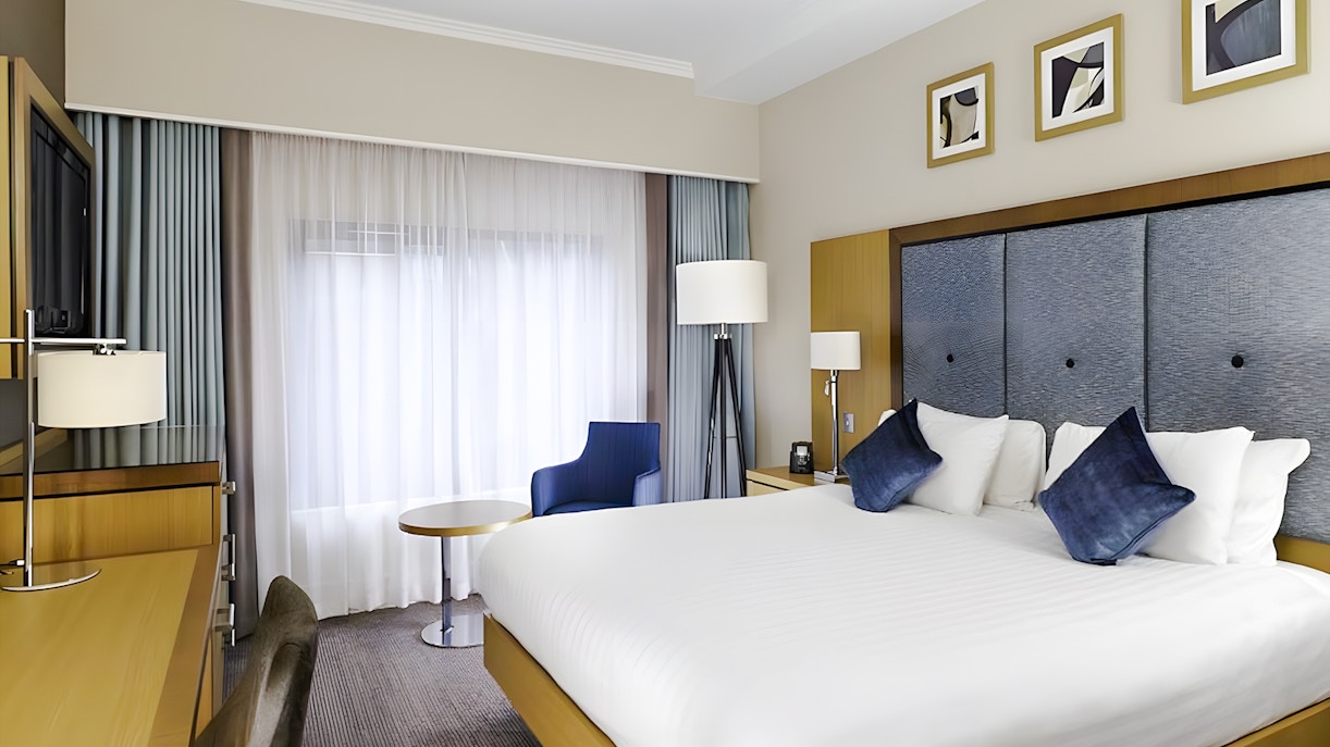 Hotel room with double bed, desk, and seating area included in Warner Bros Studio Tour package from London.