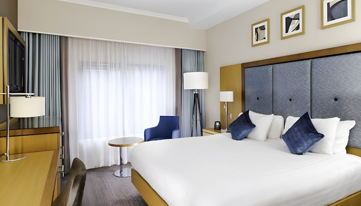 Hotel room with double bed, desk, and seating area included in Warner Bros Studio Tour package from London.