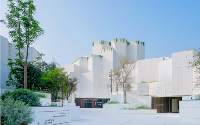 Natural History Museum Abu Dhabi exterior with modern white architecture and greenery.
