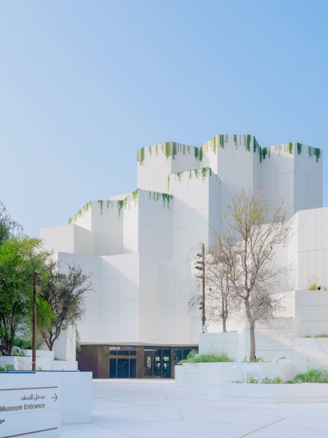 Natural History Museum Abu Dhabi exterior with modern white architecture and greenery.