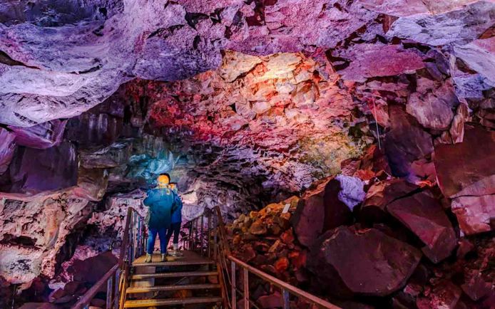 Guests exploring Raufarhólshellir Lava Tunnel with colorful rock formations.