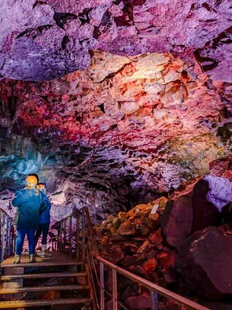 Guests exploring Raufarhólshellir Lava Tunnel with colorful rock formations.