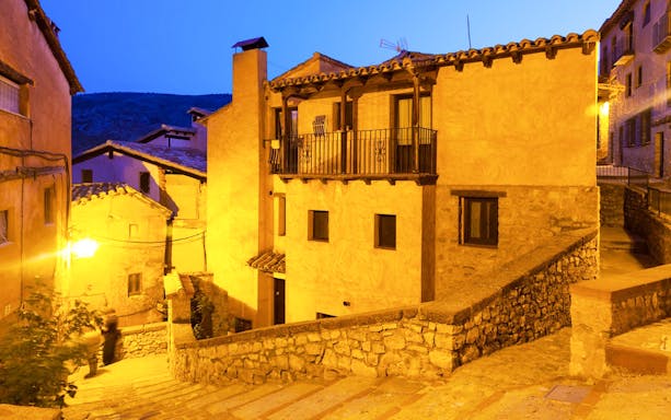 Alleyway in the Albaicín, Granada, illuminated at night with traditional houses.