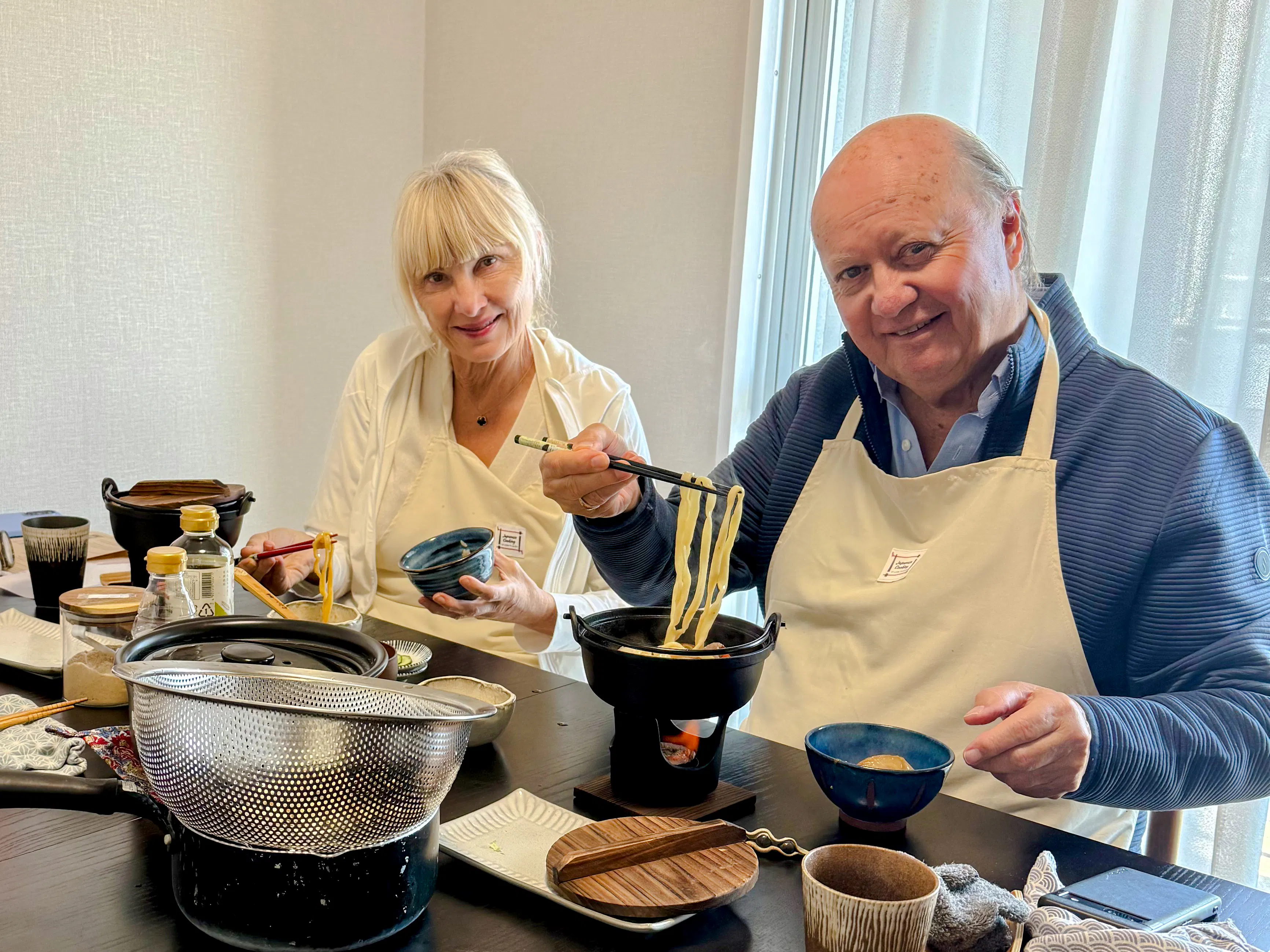 Cooking class participants preparing sukiyaki with Kobe beef in a local Kobe home.