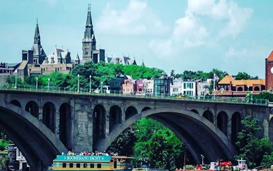 Boomerang yacht cruising on Potomac River with view of Georgetown University and Key Bridge, Washington DC.