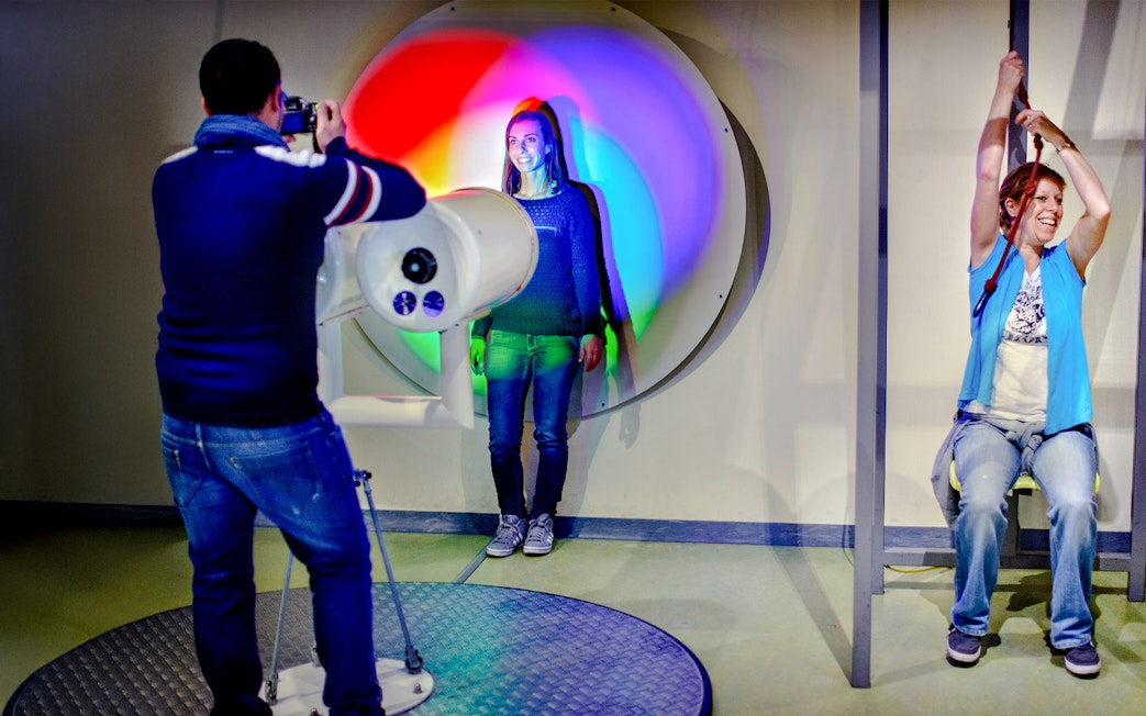 Visitors engaging with interactive light and pulley exhibits at NEMO Science Museum.