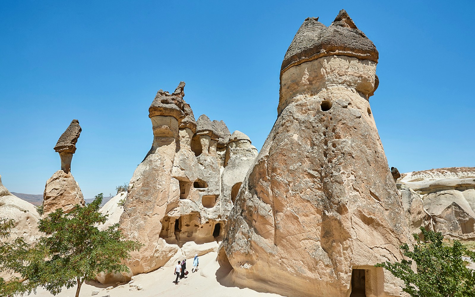 Rock formations in Pasabag Valley, Cappadocia with tourists exploring the area.