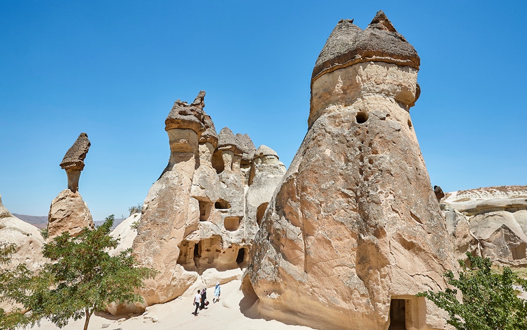 Rock formations in Pasabag Valley, Cappadocia with tourists exploring the area.