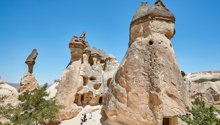 Rock formations in Pasabag Valley, Cappadocia with tourists exploring the area.