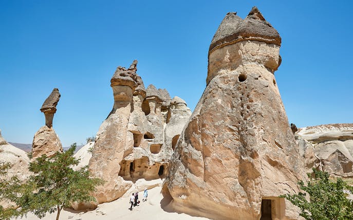 Rock formations in Pasabag Valley, Cappadocia with tourists exploring the area.