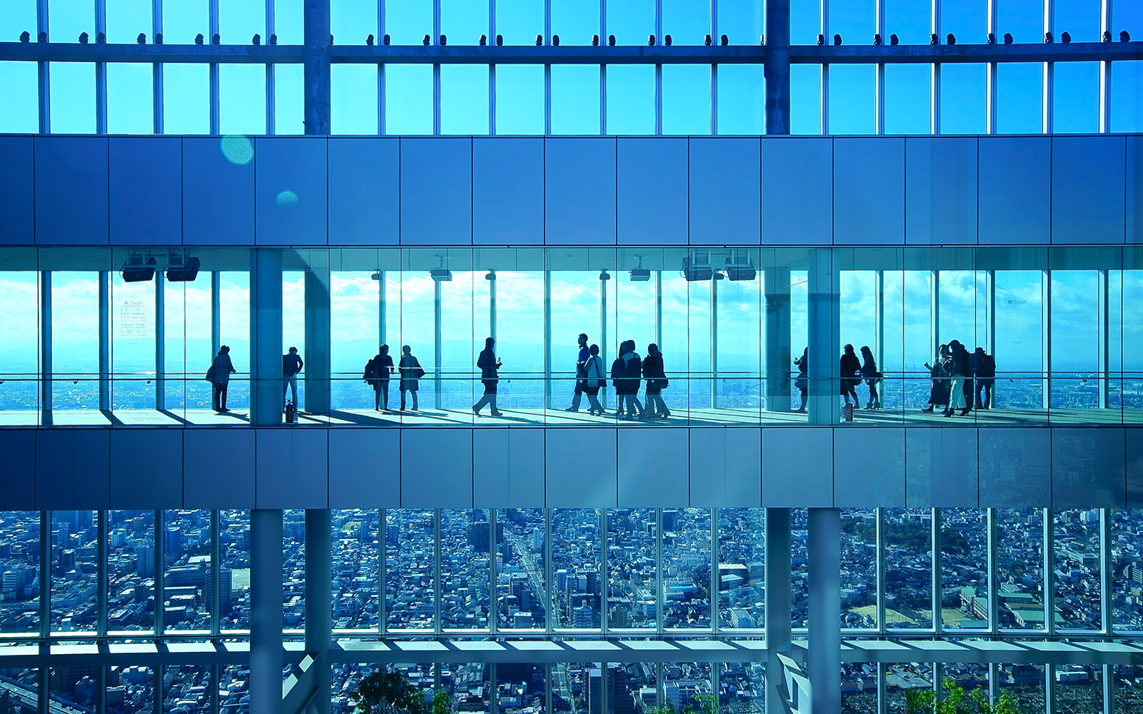 Visitors at Harukas 300 Observatory enjoying city views through large windows.