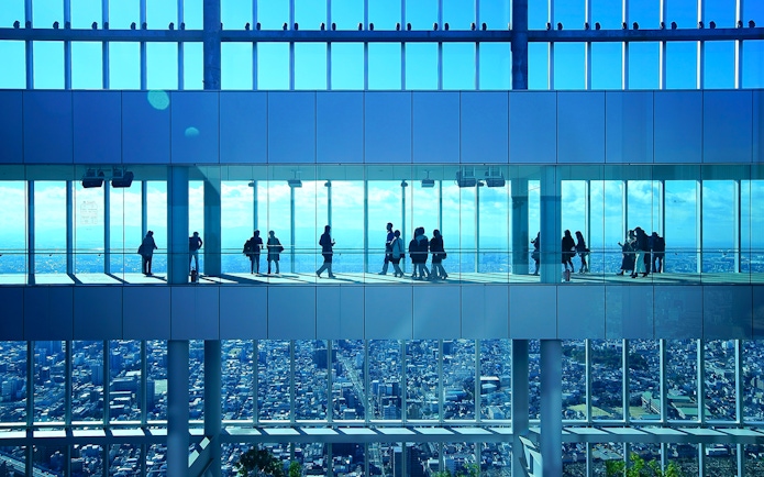 Visitors at Harukas 300 Observatory enjoying city views through large windows.