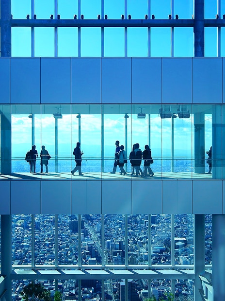 Visitors at Harukas 300 Observatory enjoying city views through large windows.