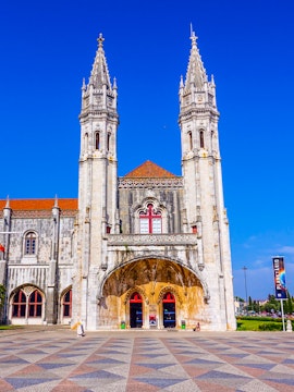 Facade of the Maritime Museum in Lisbon with twin spires and arched entrance.
