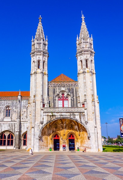 Facade of the Maritime Museum in Lisbon with twin spires and arched entrance.