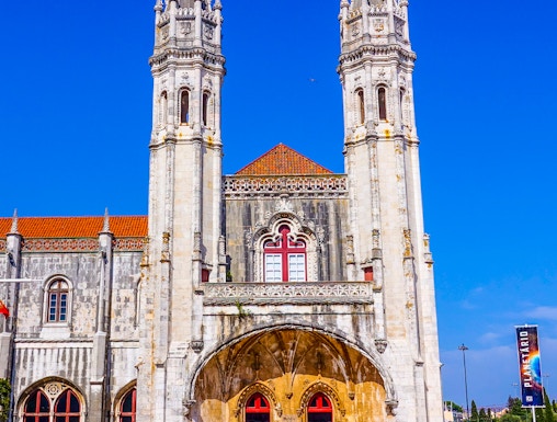 Facade of the Maritime Museum in Lisbon with twin spires and arched entrance.