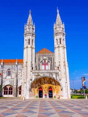 Facade of the Maritime Museum in Lisbon with twin spires and arched entrance.