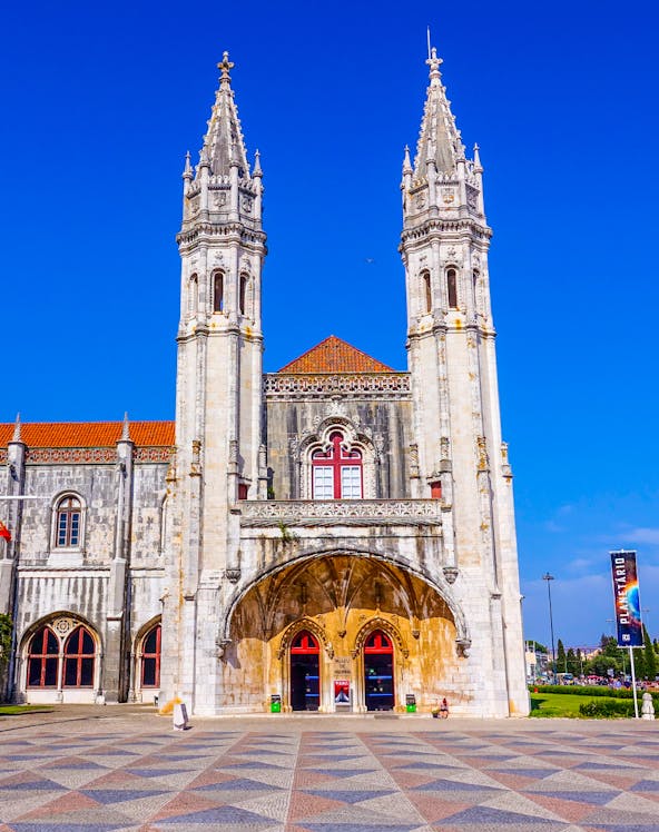 Facade of the Maritime Museum in Lisbon with twin spires and arched entrance.