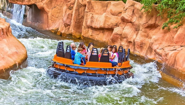 Tourists on Radja River ride at Walibi Belgium, experiencing thrilling water rapids.
