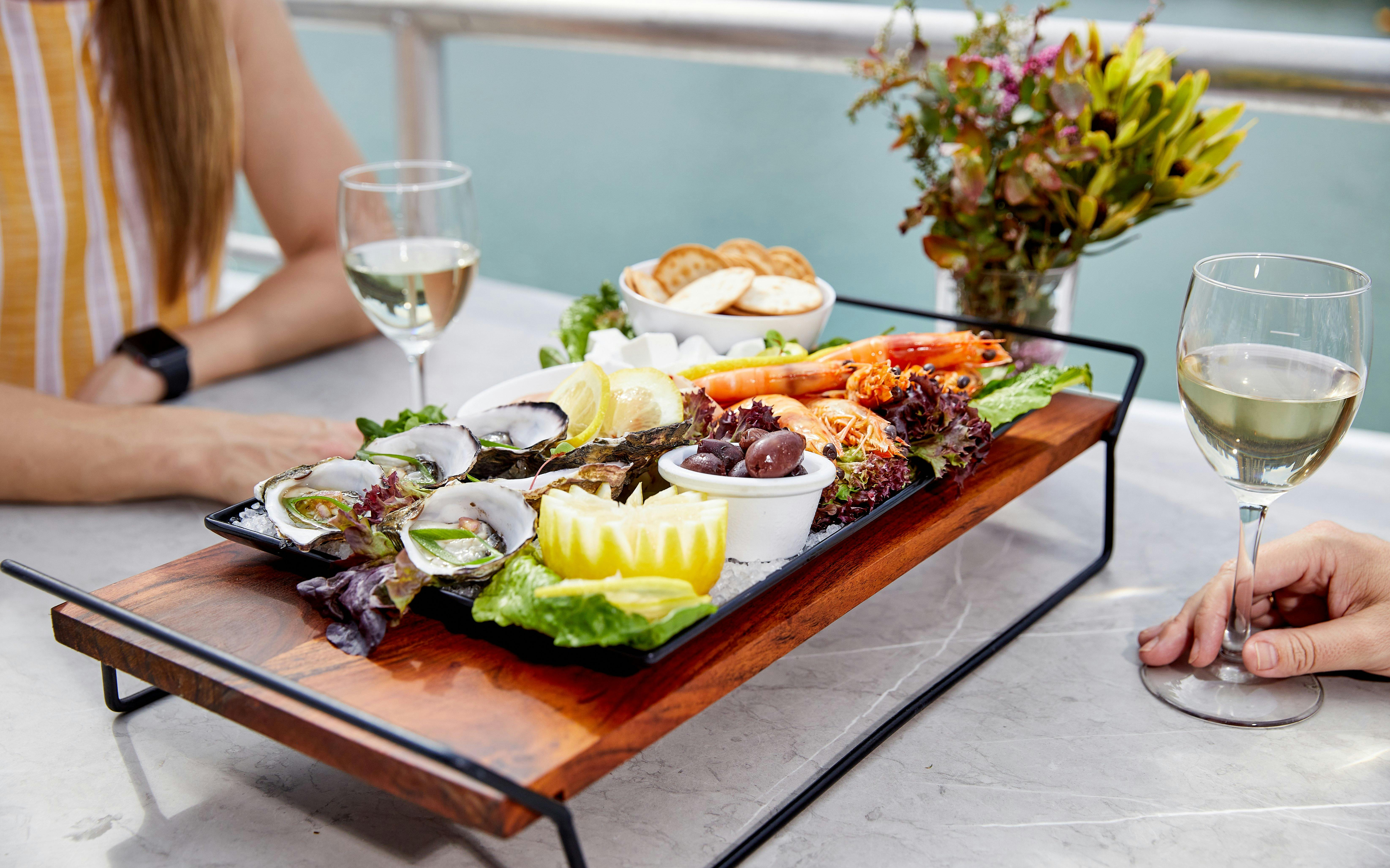 Seafood platter with oysters and prawns on Darwin Harbour lunch cruise table.