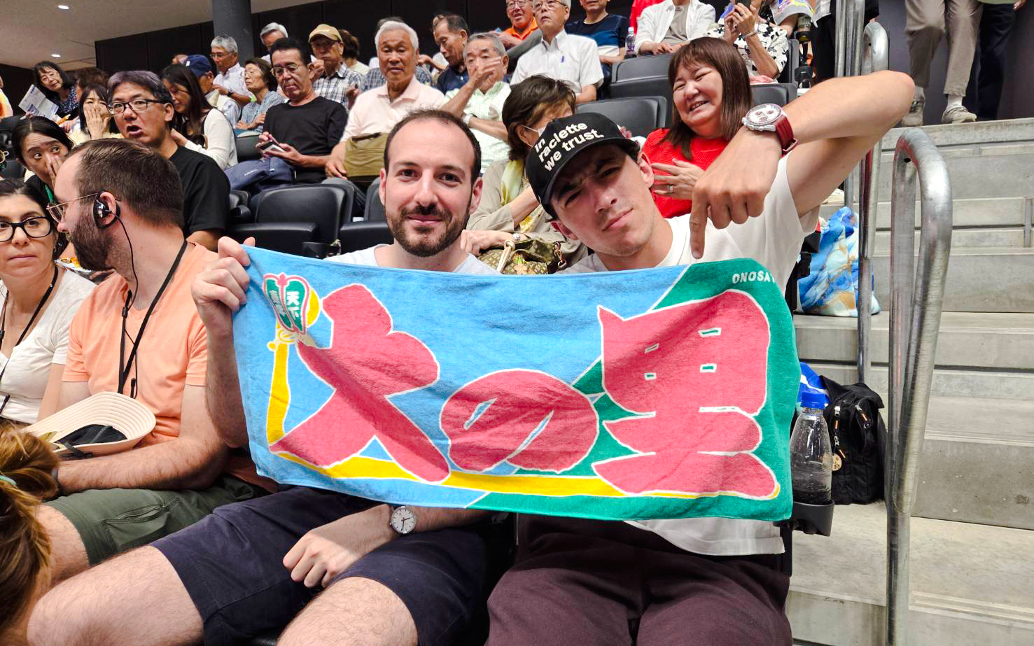Spectators holding a colorful banner at the Nagoya Grand Sumo Tournament.