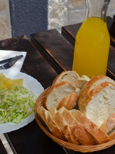 Mediterranean meal with grilled chicken, cabbage salad, bread, and juice on Blue Lagoon tour from Split.