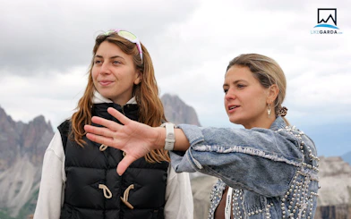 Tour guide explaining Dolomites view to visitor during Verona bus tour.
