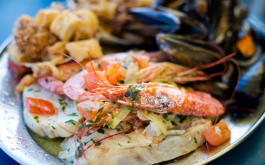 Maltese seafood platter with prawns, mussels, and fish.