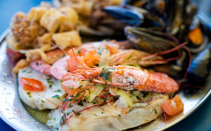 Maltese seafood platter with prawns, mussels, and fish.